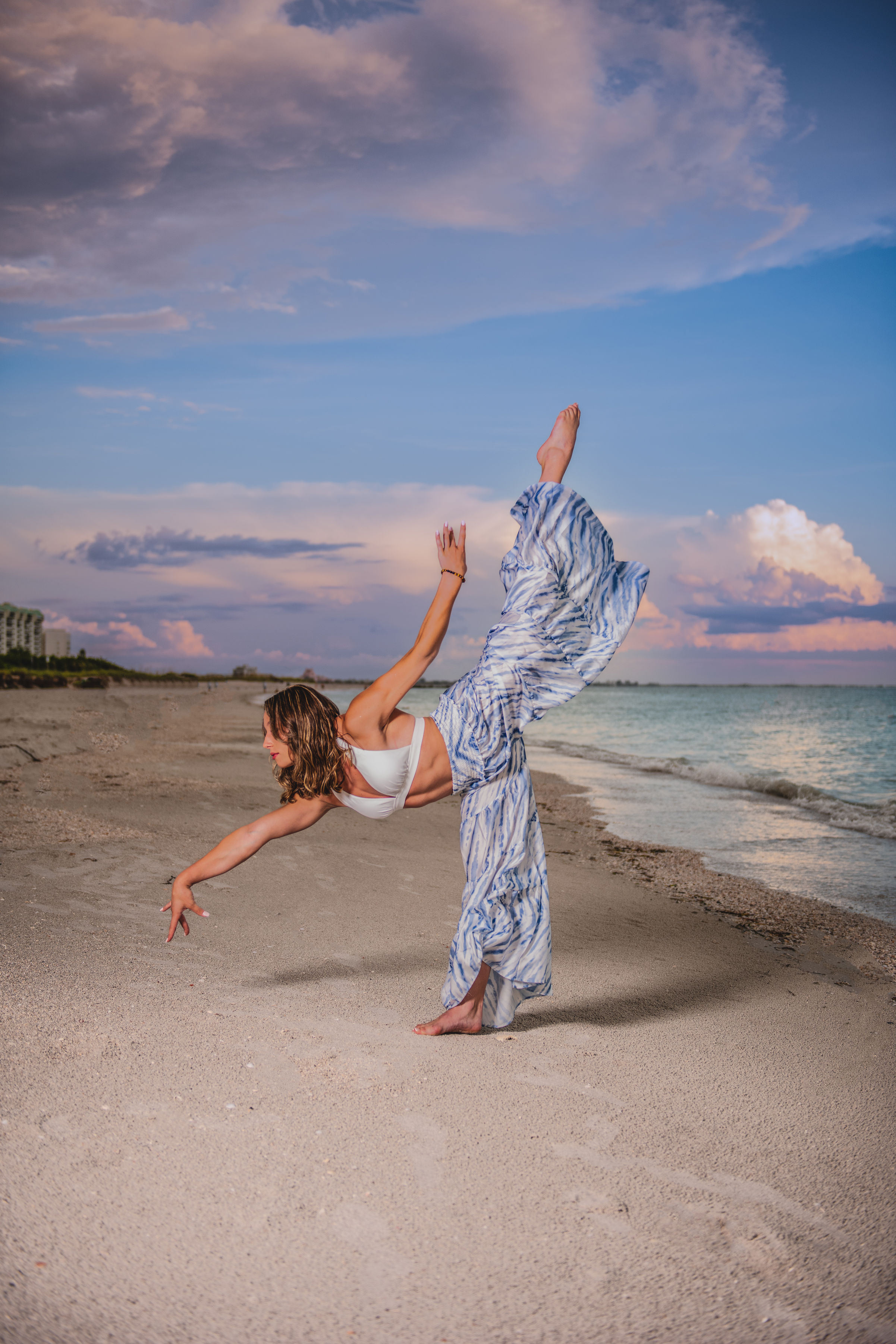 Senior gymnast performing arabesque on Clearwater Beach at golden hour